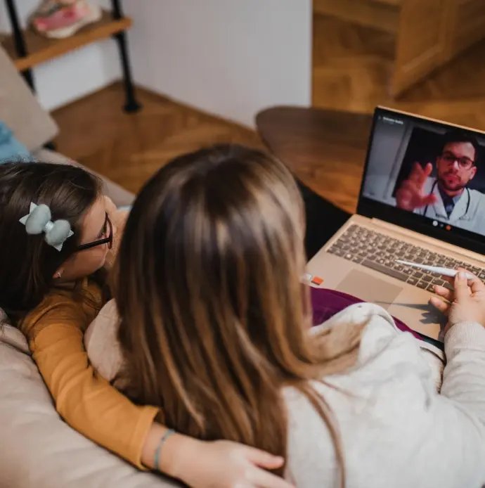 Mother and daughter having a virtual call with a doctor